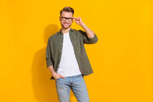 Portrait of attractive cheerful intellectual skilled guy touching specs isolated over bright yellow color background — Stockfoto