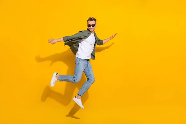 밝은 노란색 배경 위로 떨어져 점프하는 매력적 인 쾌활 한 남자의 전체 몸길이 사진 — 스톡 사진