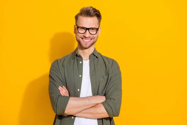 Portrait of attractive cheerful content intellectual guy folded arms isolated over bright yellow color background — стоковое фото