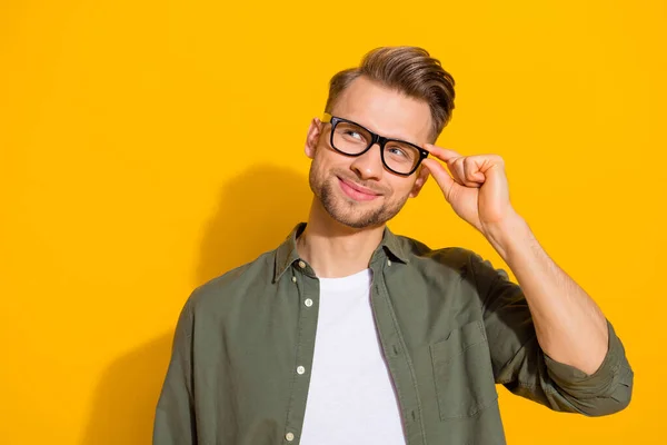 Portret van aantrekkelijke vrolijke pensive guy aanraken specs maken beslissing kopiëren ruimte geïsoleerd over helder gele kleur achtergrond — Stockfoto