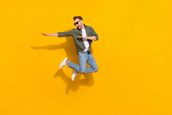 Full length body size view of attractive cheerful crazy guy jumping having fun fooling isolated over bright yellow color background — Foto de Stock