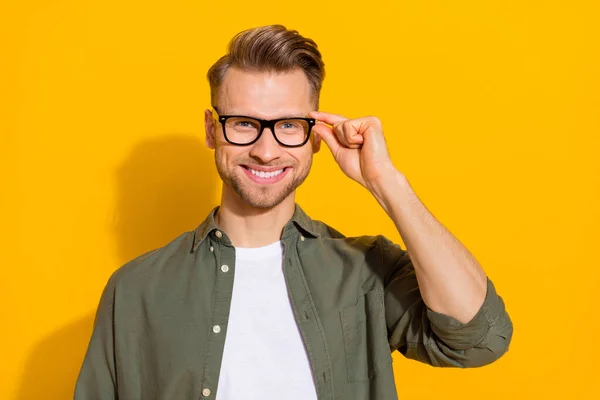 Portrait of attractive cheerful content intellectual guy touching specs isolated over vibrant yellow color background – stockfoto