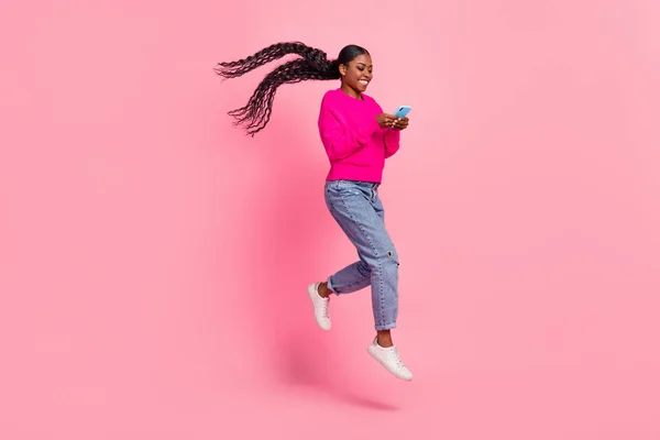 Full body photo of millennial brunette lady look telephone run wear pullover jeans footwear isolated on pink background — Stock Fotó