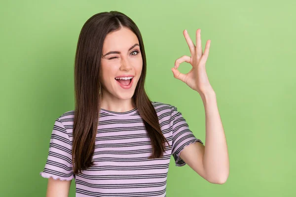 Foto de alegre bonita senhora olho piscar mão dedos demonstrar símbolo okey isolado no fundo cor verde — Fotografia de Stock