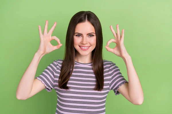 Portrait of attractive cheerful brown-haired girl showing double ok-sign ad yes isolated over bright green color background — Stockfoto