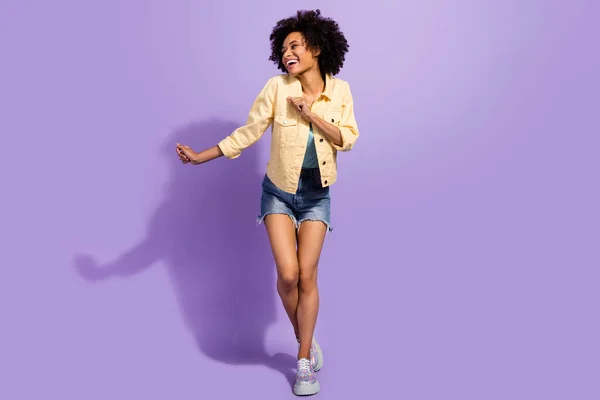 Photo of sweet charming woman dressed yellow jeans jacket smiling dancing isolated purple color background