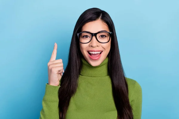 Fénykép a hűvös fiatal barna hölgy index up kopás szemüveg zöld pulóver elszigetelt kék színű háttér — Stock Fotó