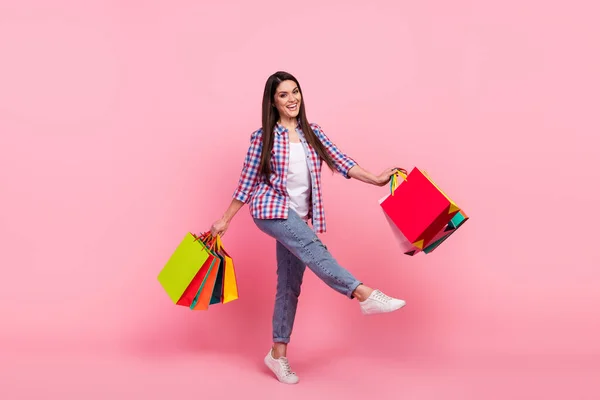 Full size photo of young brunette lady do shopping wear shirt jeans sneakers isolated on pink background — Stock Fotó