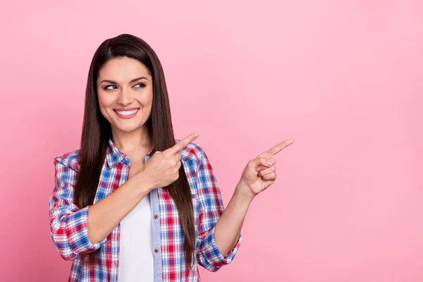 Photo of adorable dreamy woman wear plaid shirt pointing looking empty space isolated pink color background — Stockfoto