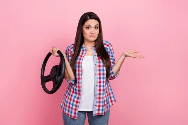 Photo of unsure mature brunette lady shrug shoulders hold wheel wear checkered shirt isolated on pink color background — 图库照片