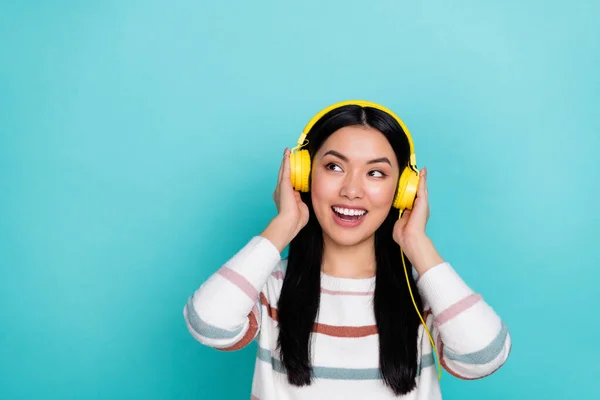 Photo of impressed young lady listen music look promo wear headphones white pullover isolated on turquoise color background — Stockfoto