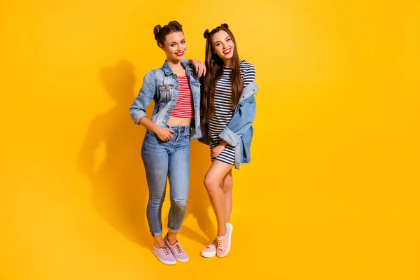 Full size portrait of two lovely satisfied girls embrace toothy smile good mood isolated on yellow color background — Stok fotoğraf