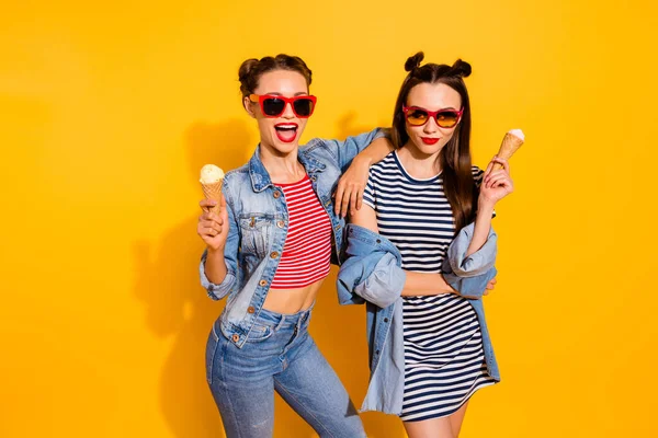 Portrait of two nice carefree brunette hair girls hold ice cream cone hug embrace isolated on yellow color background — Stock Fotó