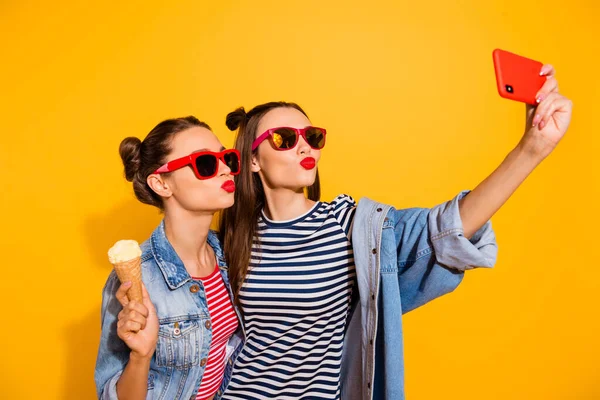 Portrait of two charming nice ladies make selfie eat ice cream kiss lips isolated on yellow color background — Stock Fotó