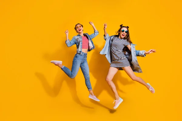 Full body portrait of two pretty cheerful people jumping good mood isolated on yellow color background — Fotografia de Stock