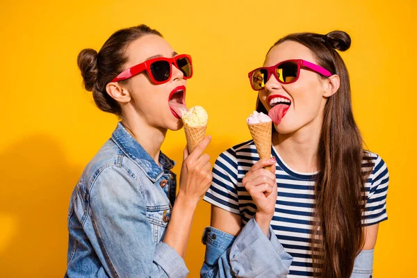 Photo of two ladies have free time eat tasty fresh ice cream wear denim jeans isolated shine color background — Stock fotografie