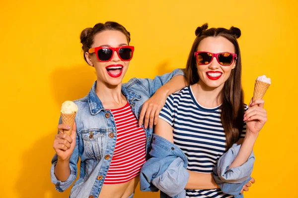 Photo of two excited carefree pretty people hug enjoy ice cream isolated on yellow color background — Zdjęcie stockowe