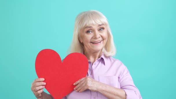 Aged lady get red big heart card fist up achieve isolated cyan color background — Video Stock