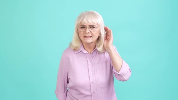 Senhora envelhecida ombros encolher de ombros não ouvir notícias isolado cor ciano fundo — Vídeo de Stock