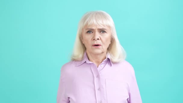 Senhora envelhecida impressionado horror guerra novidade isolado aquamarine cor fundo — Vídeo de Stock