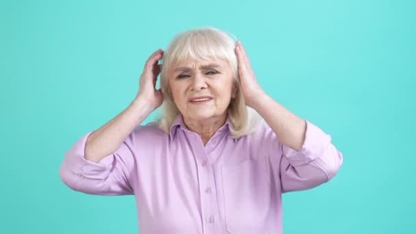 Пожилая женщина ужасная головная боль симптом болезни изолированный голубой цвет фона — стоковое видео