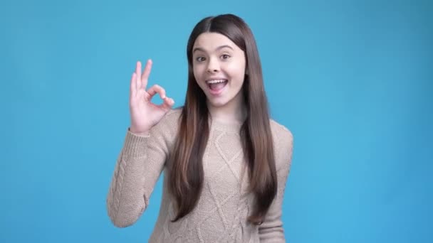 Латинська дівчина з позитивним кольором робить добрий символ ізольованого синього кольору — стокове відео