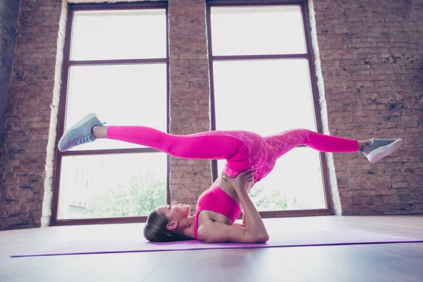 Full size photo of determined muscular lady trainer doing aerobics twine legs upside down position in modern loft — стоковое фото