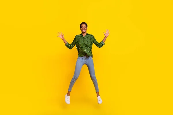 Photo of funky excited androgynous person dressed smart casual jumping high isolated yellow color background — Stockfoto