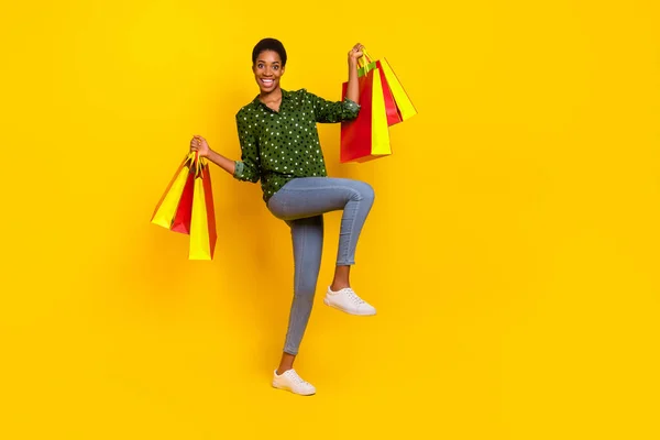 Foto von aufgeregt funky androgyne Person gekleidet smart lässig zu Fuß halten Käufer isoliert gelbe Farbe Hintergrund — Stockfoto