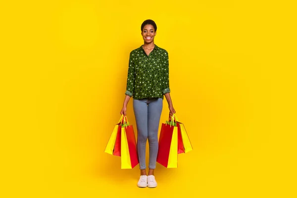 Photo of funny positive trans human wear smart casual clothes holding bargains isolated yellow color background — Stockfoto