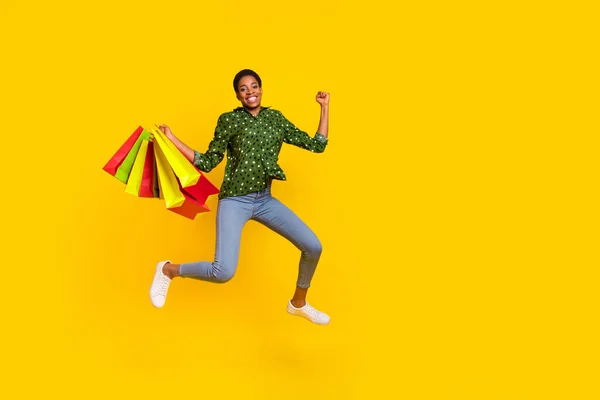Photo of hurrying excited androgynous person dressed smart casual running fast rising fist empty space isolated yellow color background — 스톡 사진