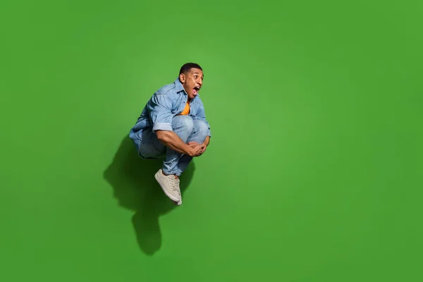 Full length photo of attractive overjoyed screaming man have fun jumping into water pool isolated on green color background — 스톡 사진