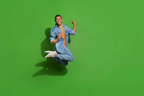 Foto de larga duración del joven atractivo saltando en la emoción celebrar la victoria aislado en el fondo de color verde — Foto de Stock