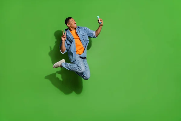 Perfil de cuerpo completo lado de la foto de un joven influencer tomar selfie show v-sign hacer entrada de blog aislado sobre fondo de color verde — Foto de Stock
