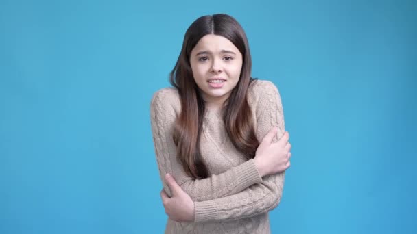 20 대 의 라틴 여인 이 차가운 옷을 입고 있는 것을 보면 파란 배경 이 분리되어 있다 — 비디오
