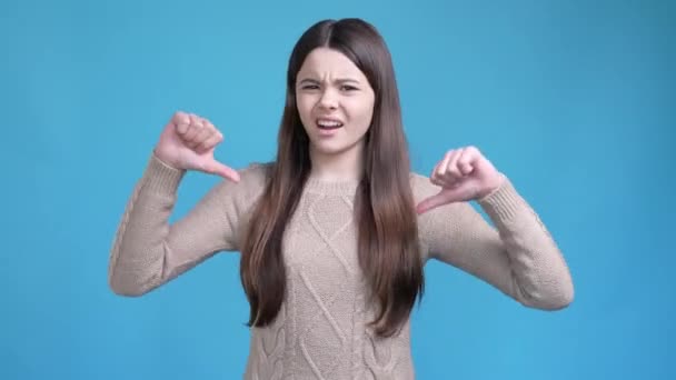 Teen lady make thumb down symbol not like ads isolated blue color background — Stock Video