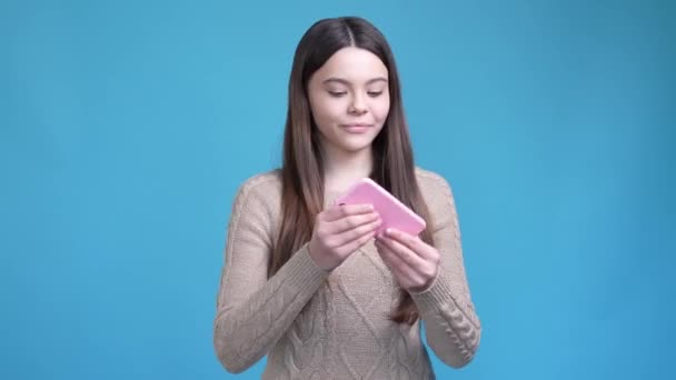 Adolescente dama llamada gadget regocijo ganar puño hasta aislado color azul fondo — Vídeo de stock