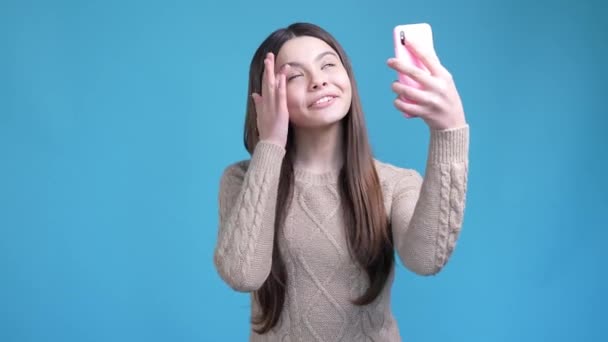 Adolescente influencer hacer selfie dispositivo apuntar a sí misma aislado color azul fondo — Vídeo de stock