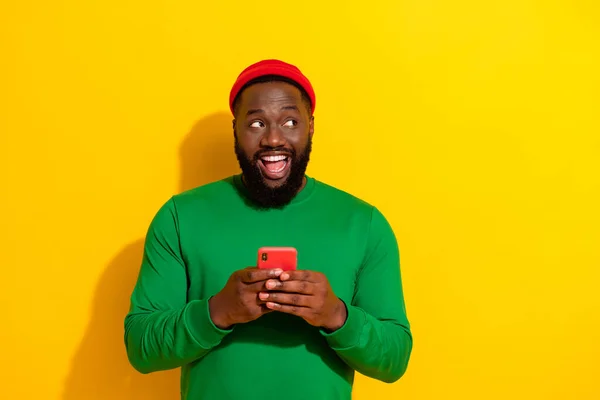 Portrét atraktivní veselý chlap pomocí zařízení vytváří nový příspěvek smm vliv izolované přes jasně žluté barvy pozadí — Stock fotografie