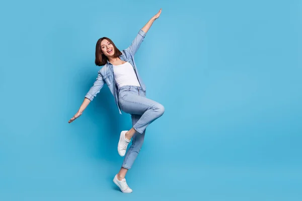 Photo of childish fooling lady dressed denim shirt empty space dancing arms sides isolated blue color background —  Fotos de Stock