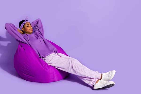 Photo of relaxed dreamy sleepy transgender enjoy beanbag nap wear headband hoodie isolated purple color background — Stok fotoğraf