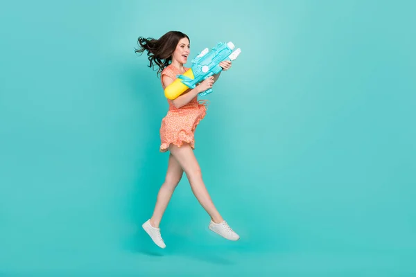 Photo of cute excited woman wear orange outfit jumping high having fun empty space isolated turquoise color background — Stock Fotó