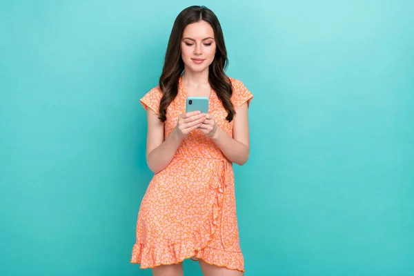 Foto de dulce linda dama vestida ropa naranja aplicación de comunicación gadget moderno aislado color verde azulado fondo — Foto de Stock
