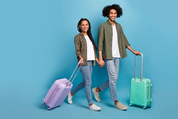 Foto av två vänner makar steg check i terminal hold bagage helg slitage skjorta jeans isolerad blå färg bakgrund — Stockfoto