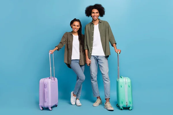 Photo of two guy lady friends passenger hold baggage leaving rest wear shirt denim jeans isolated blue color background — Φωτογραφία Αρχείου