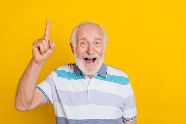 Retrato de atraente homem de cabelos grisalhos alegres apontando para cima bom espaço de cópia solução isolado sobre fundo de cor amarelo vívido — Fotografia de Stock