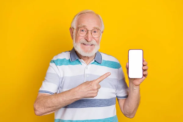 Portrait of attractive cheerful grey haired man showing display copy space app isolated over bright yellow color background — Stok fotoğraf