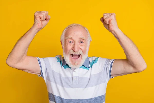 Portrait of attractive lucky cheerful grey haired man rejoicing having fun isolated over bright yellow color background — Foto de Stock
