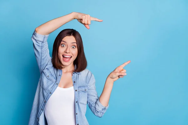 Foto de menina animado funky indicar dedos espaço vazio oferta promo isolado no fundo de cor azul — Fotografia de Stock