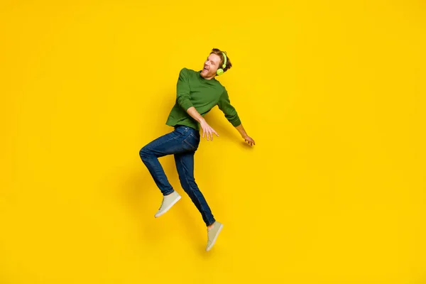 Foto de cuerpo entero de un hombre guay usando auriculares de jersey bailando espacio vacío aislado color amarillo fondo —  Fotos de Stock